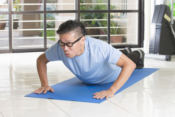 asian senior male streching at the gym