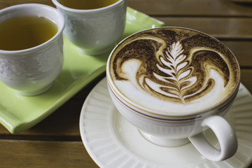 cup of hot cappuccino over with hot tea