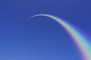Rainbow Arcing Through Blue Sky