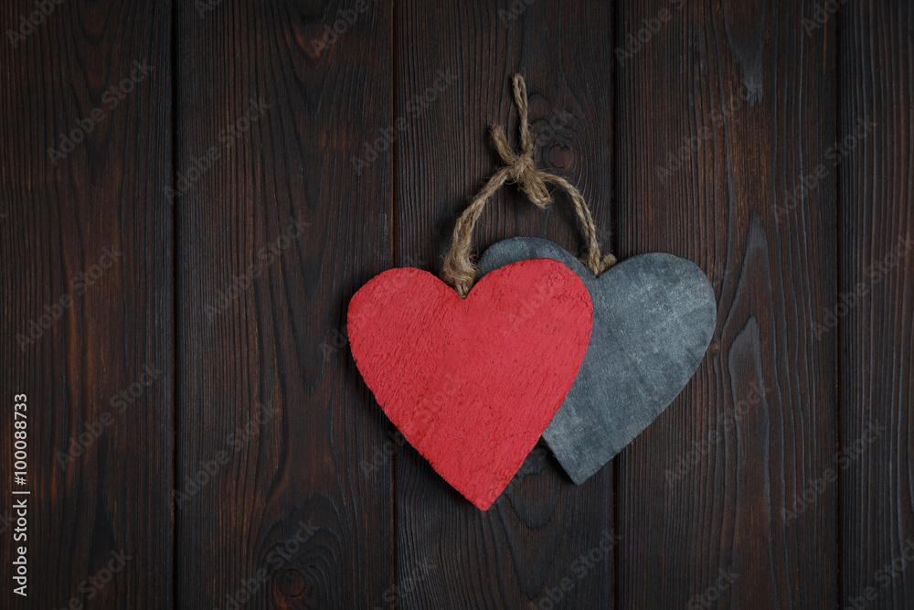 Wall mural wooden hearts on dark wood background