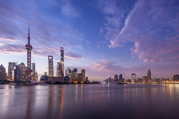 waterfront cityscape and illuminated skyline at dawn