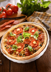 Tart (Quiche) with tomatoes, basil, salami, black olives and che