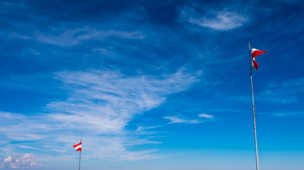 Fototapeta premium Italian flag waving in the sky with clouds, Monte Grappa, Italia.