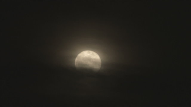 Shot of a full moon at with clouds covering the bottom half