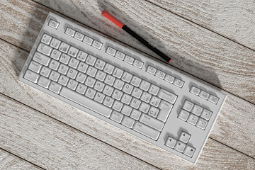 White spanish keyboard and red marker on wooden table