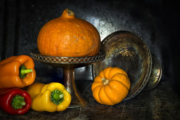 Pumpkin, squash and a selection of Romano peppers in vintage style on dark rustic background