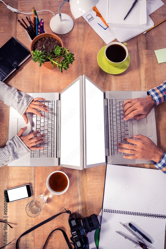 Poster cropped image of hands using laptops