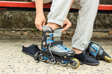 Woman putting on roller skates outdoor.