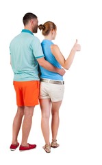 young couple pointing at wal Back view