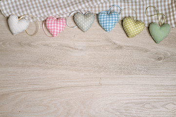 Background for greeting card with stuffed cotton hearts on wood