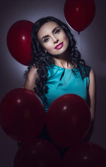 Happy young woman with red latex balloons