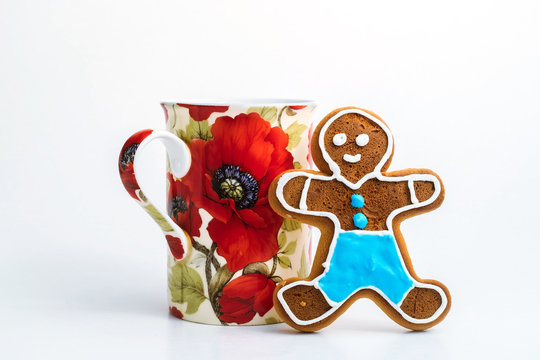 Gingerbread man and cup of tea on white background