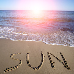 Sun written on wet sand