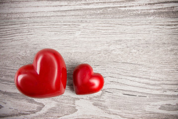 Two red stone hearts on neutral background, text space