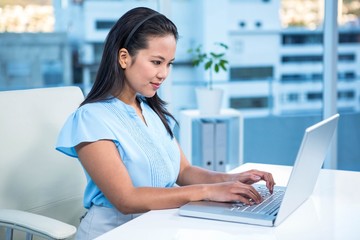 Smiling businesswoman using laptop