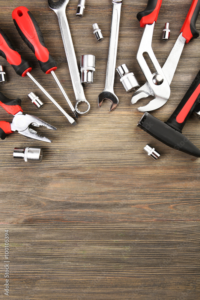 Wall mural different kinds of tools on wooden background, top view