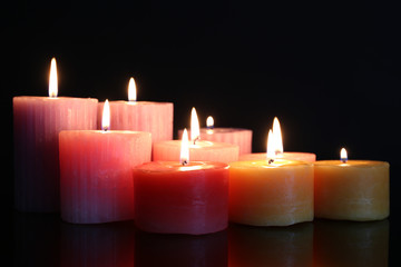 Many burning small candles on dark background