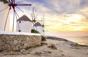 Windmills in Chora,Mykonos,Greece at sunset.Greek whitewashed architecture,a popular landmark,tourist destination on the island of winds,deep blue sky,Aegean sea. Wind mills are now decorative.