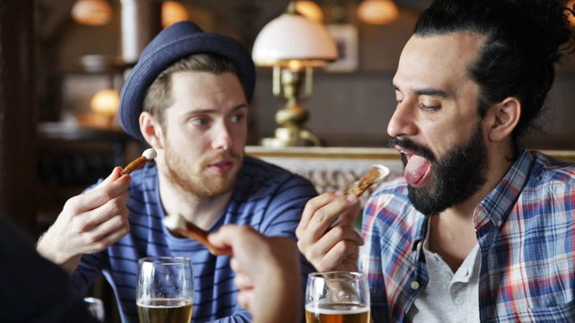 happy male friends drinking beer at bar or pub