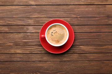 Cup of coffee on wooden table, top view