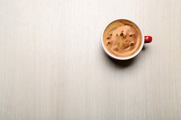 Cup of coffee on light background, top view