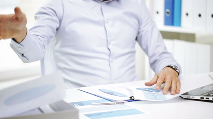 busy businessman with laptop and papers in office