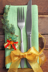 Christmas serving cutlery with napkin on a wooden background, close up