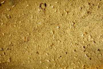 Old gold grunge wall with peeling paint with old concrete