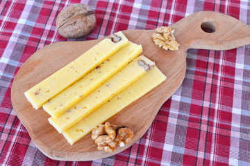Fototapeta na wymiar Pieces of cheese with walnuts on a wooden board