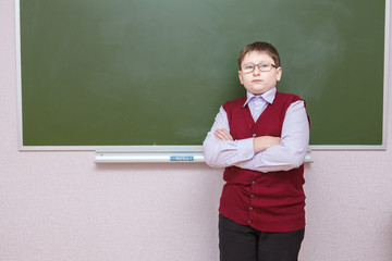 boy standing with his arms crossed at a school board