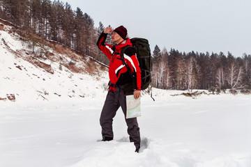 hiker with a map of location, winter hiking, expedition