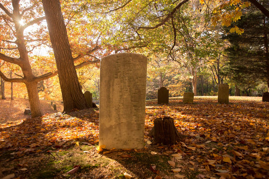Old graveyard cemetery with headstone on fall day