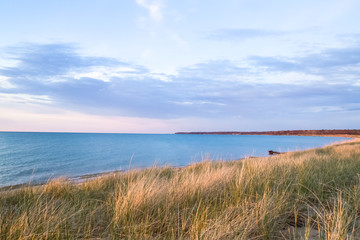 Summer Day. Sunny summer afternoon at the beach with dune grass in the foreground. Port Crescent State Park. Port Austin, Michigan.