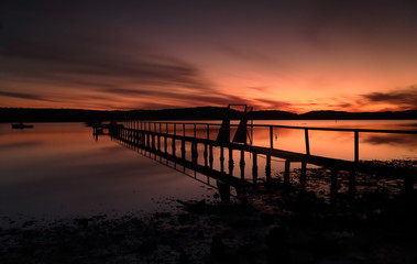 Fototapeta na wymiar Summer sunset silhouettes at Kincumber jetty