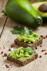 Sandwiches with black rye bread and avocado mousse with spices,