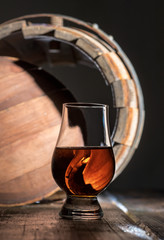 A glass of whiskey on the oak barrel