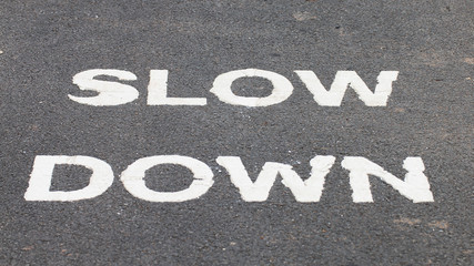 Fototapeta premium A warnning sign SLOW DOWN painted on the bike lane