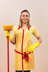 Obraz premium Portrait of beautiful housewife holding broom