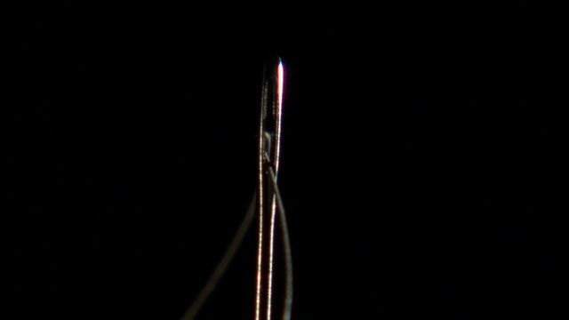 Extreme close up of a needle being threaded.