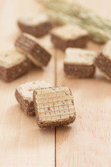 Wafers with chocolate on wooden background.