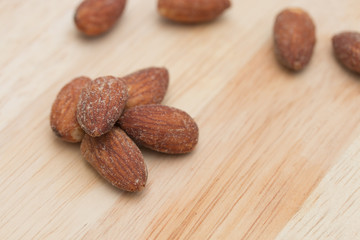 Almonds on wooden background.