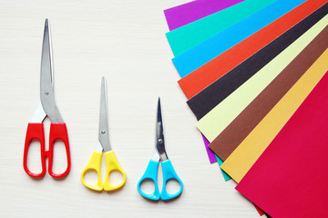 Three scissors and many sheets of multicolored paper