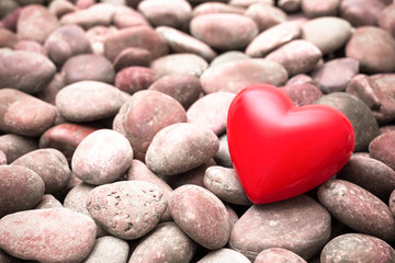 Fototapeta premium Red heart on pebble stones