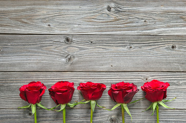 Fototapeta na wymiar Red roses on wooden board