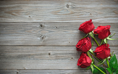 Fototapeta na wymiar Red roses on wooden board