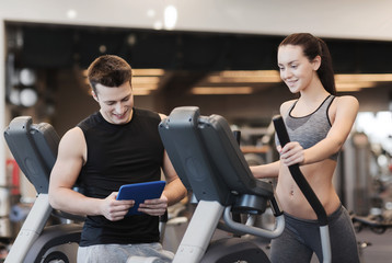 woman with trainer exercising on stepper in gym