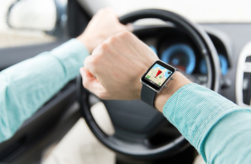 close up of man driving car with gps on smartwatch