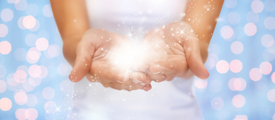 Fototapeta premium magic twinkles or fairy dust on female hands