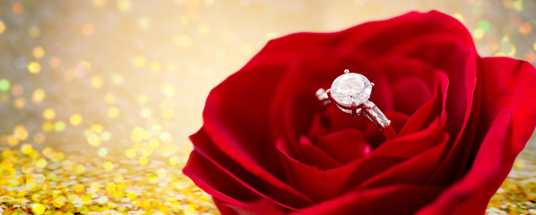 close up of diamond engagement ring in rose flower