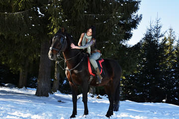 Fototapeta na wymiar young woman riding horse outdoor in winter